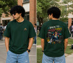 Person wearing a green t-shirt with a graphic design on the back, standing outdoors.
