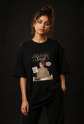 Person wearing a black t-shirt with a graphic design on a dark background