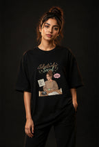 Person wearing a black t-shirt with a graphic design on a dark background