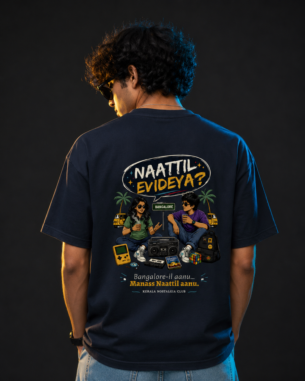 Person wearing a navy blue t-shirt with a graphic design on the back against a black background