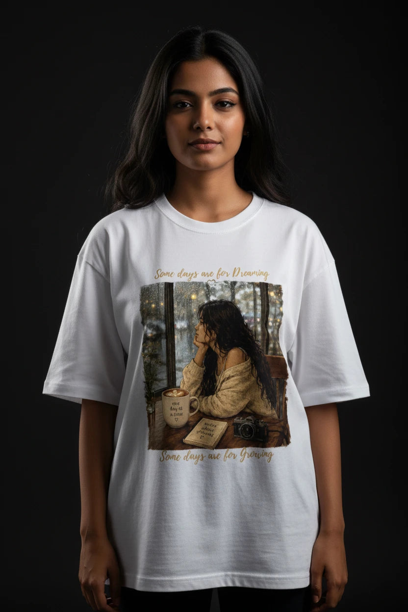 Person wearing a white t-shirt with a graphic design on a dark background
