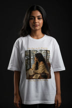 Person wearing a white t-shirt with a graphic design on a dark background