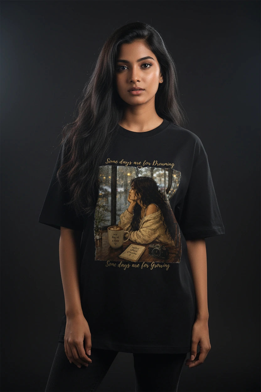 Person wearing a black t-shirt with a graphic design on a dark background
