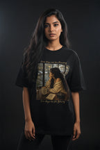 Person wearing a black t-shirt with a graphic design on a dark background