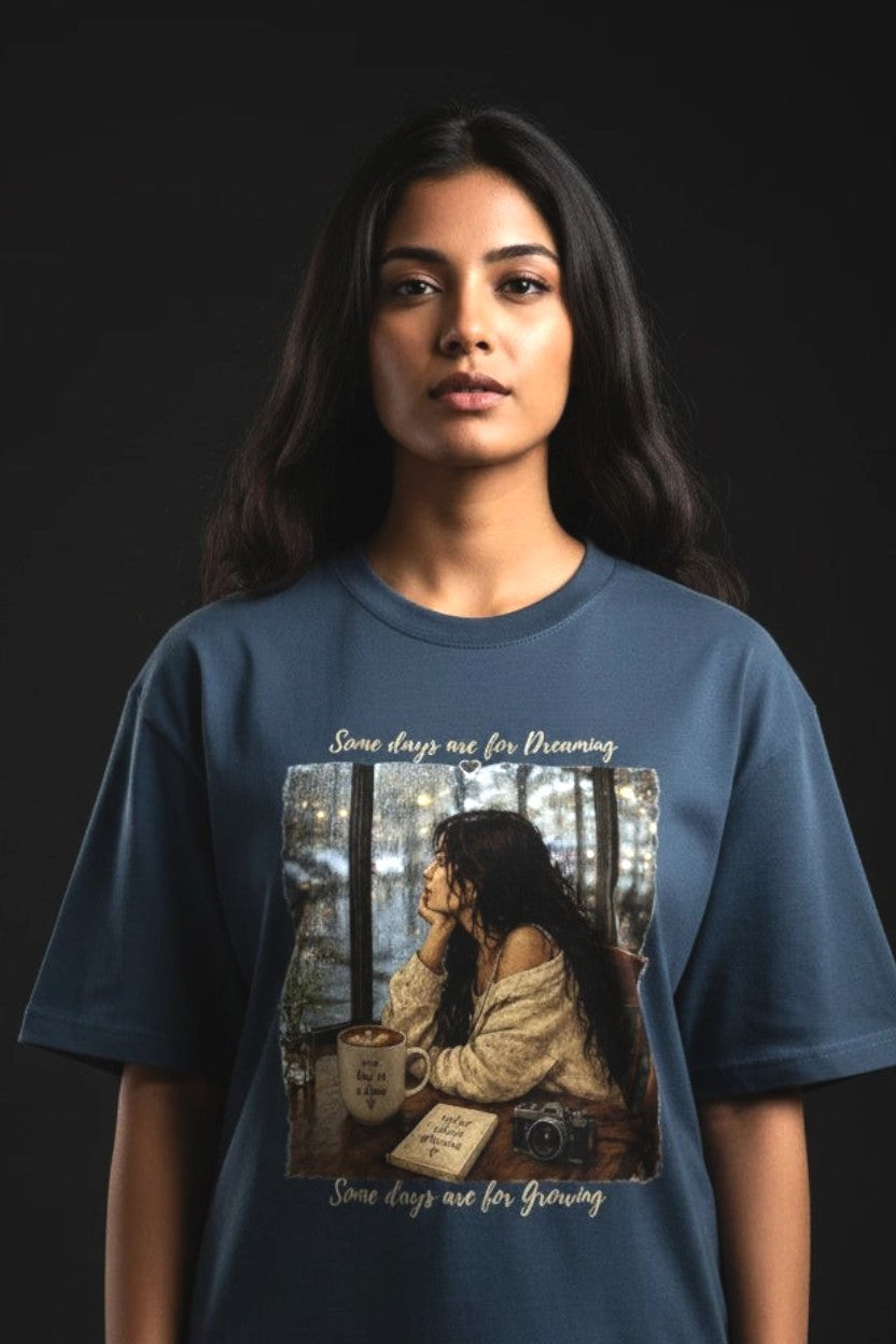 Person wearing a blue t-shirt with a graphic design on a black background
