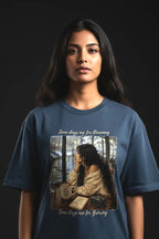 Person wearing a blue t-shirt with a graphic design on a black background