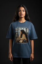 Person wearing a blue t-shirt with a graphic design on a black background