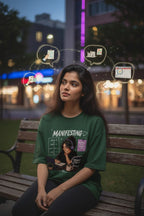 vcreate4uhub.co.in green graphic t-shirt with "Manifesting" text and illustration of woman working on laptop.